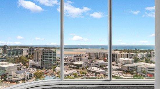 A view from inside one of the tenancies at 50 first avenue. Floor to ceiling windows show expansive views across Maroochydore, with the ocean in the background.