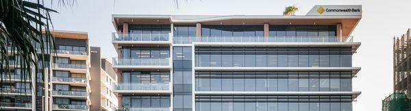The upper floors of Foundation Place, consisting of several floors of modern glass façades. The Commonwealth Bank’s logo is featured on the top right corner of the building.